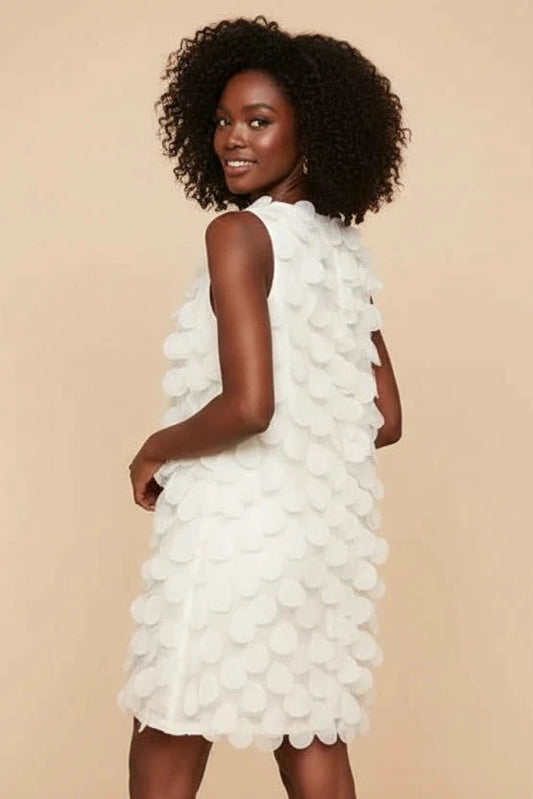 model wearing sleeveless textured petal dress chic feminine outfit-side view