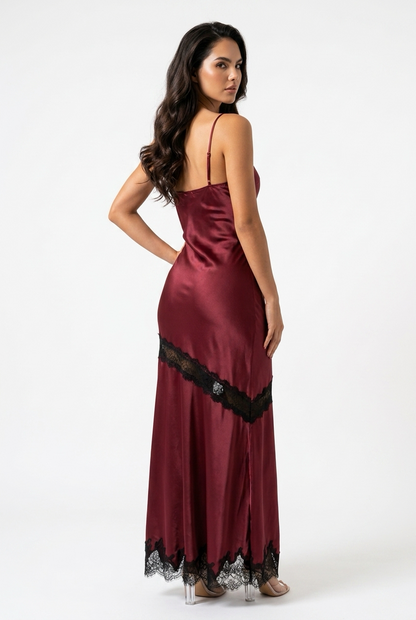 A woman modeling a burgundy satin slip gown with black lace trim, shown from the back against a plain white studio background.