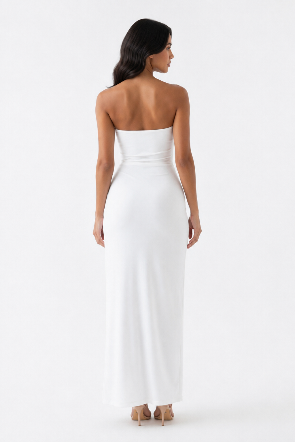 A woman shown from the back wearing a strapless white maxi dress with a fitted waist and flowing skirt, photographed against a clean white studio background.