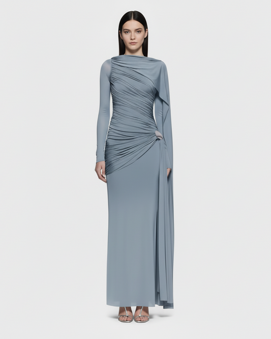Woman wearing a long, light blue dress with a draped design on a white background