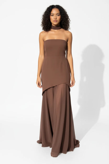 Woman wearing a coffee brown strapless dress on a white background