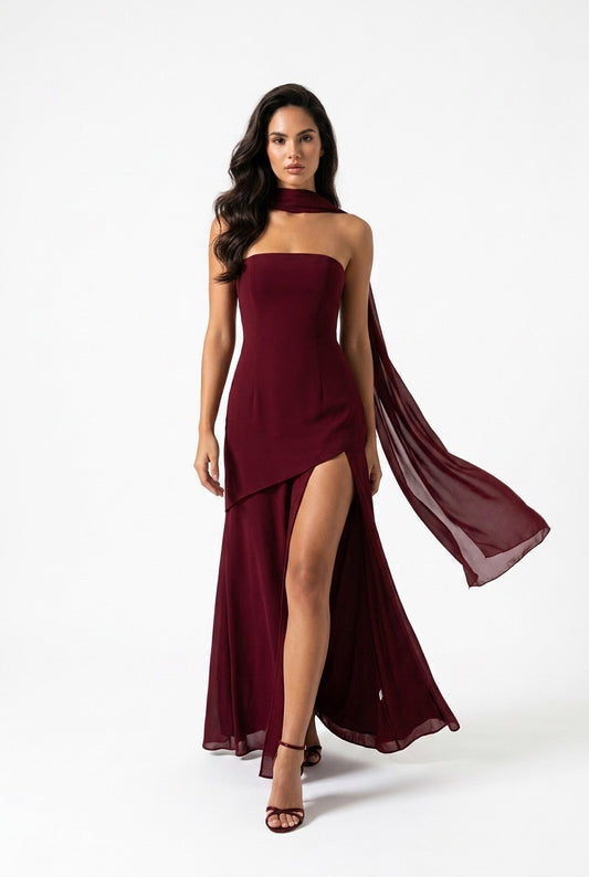 Woman wearing a burgundy evening gown with a sheer overlay on a white background
