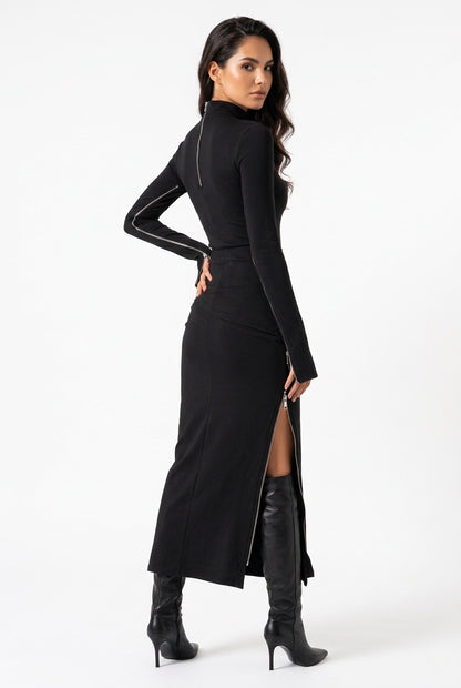 A woman modeling a black long-sleeve mock-neck midi dress with a high thigh slit, shown from a three-quarter back angle against a plain white studio background.