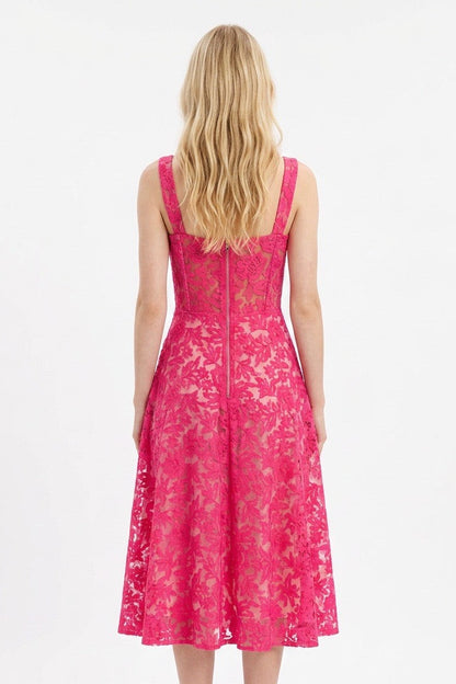 Woman wearing a pink lace dress on a white background