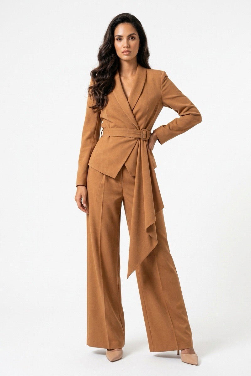 A woman modeling a camel brown wrap-style blazer with matching wide-leg trousers, photographed against a clean white studio background.