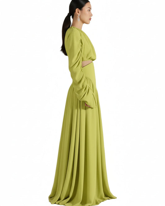 Woman wearing a long green dress against a beige background