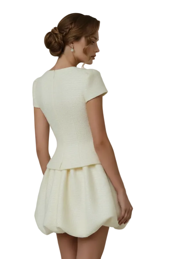 Woman wearing a white dress against a plain background