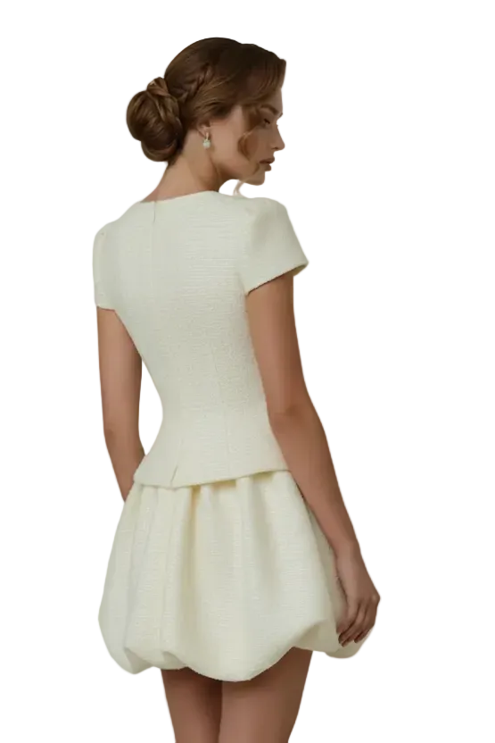 Woman wearing a white dress against a plain background