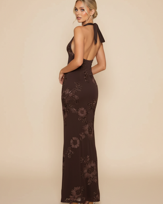 Woman wearing a dark brown evening gown with floral embroidery on a beige background