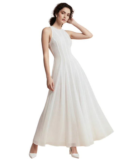 Woman wearing a white dress against a beige background